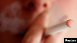 A woman smokes an e-cigarette, an electronic substitute in the form of a rod, slightly longer than a normal cigarette, in Bordeaux, southwestern France, in this file photo.