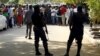 Policemen stand guard as supporters of Indigenous People of Biafra leader Nnamdi Kanu rallies before appearance in magistrate court, Abuja, Nigeria, Dec. 1, 2015.