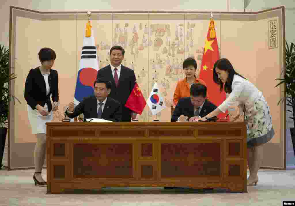 China's President Xi Jinping and his South Korean counterpart Park Geun-hye attend a signing ceremony after a summit meeting at the Blue House in Seoul, July 3, 2014. 