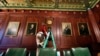 Bethany Gill climbs a ladder to wind a clock in a Pennsylvania Senate hearing chamber, in Harrisburg, Pennsylvania, Dec. 13, 2024. It's one of 273 clocks in Pennsylvania's ornate state Capitol complex buildings that must be wound by hand.