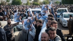 People hold photos of a child killed in the Iranian strikes at the house of Peshraw Dizayi during a protest in front of the U.N. office in Irbil, Iraq, Jan. 16, 2024. Dizayi, a prominent Kurdish businessman, was killed in one of the Irbil strikes along with members of his family.