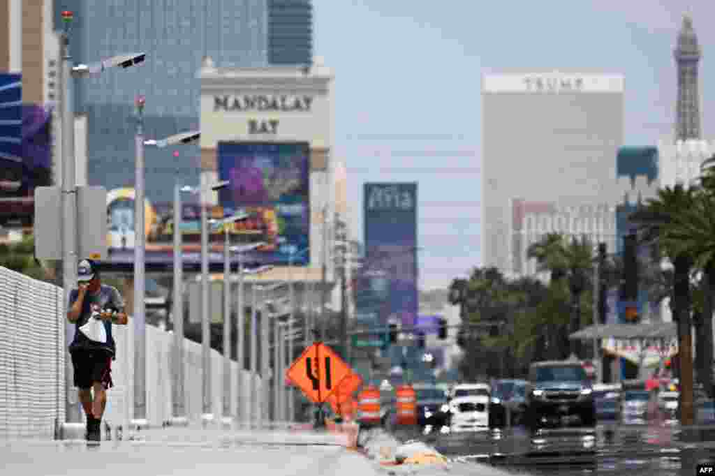 Ondas de calor causam distorção no horizonte enquanto uma pessoa caminha pela South Las Vegas Blvd em Las Vegas, Nevada, a 30 de julho de 2023, quando as temperaturas atingem mais de 100 graus Fahrenheit (37,78C). &nbsp;