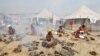 FILE - Hindu holy men offer prayers while sitting inside circles of burning "Upale" (or dried cow dung cakes) on the occasion to mark the Basant or spring festival, on the banks of river Ganga in Allahabad, India, Feb. 1, 2017.