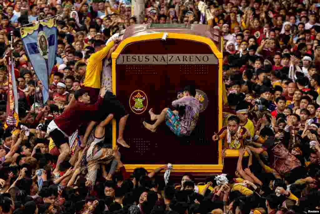 Filipino Catholic devotees jostle to touch the carriage carrying the statue of the Black Nazarene during the annual procession on its feast day in Manila, Philippines.