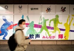 A man wearing a face mask visits the Shinjuku City Hall promoting the Tokyo 2020 Olympics, rescheduled for this summer, in Tokyo on Jan. 29, 2021.