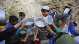 Afghan villagers flock around free food donated by other villagers as they prepare to break their fast during the holy month of Ramadan in Kabul.