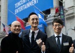 FILE - Tao Sang Tong, center, chairman of Tencent Music Entertainment; Cussion Kar Shun Pang, right, the company's CEO; and Guomin Xie, its co-president, are pictured at the New York Stock Exchange prior to the Chinese company's IPO, Dec. 12, 2018.