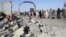 Afghan security forces and civilians walk at the site of a suicide attack in Lashkar Gah, capital of Helmand province, June 4, 2015. 