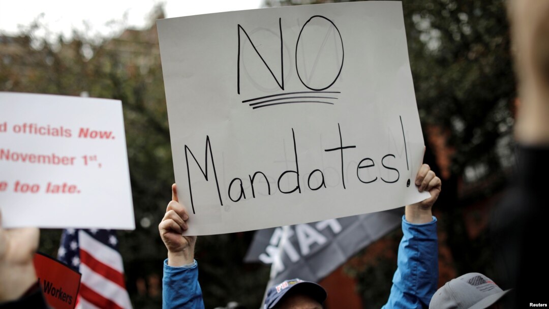 FILE: A demonstrator holds a sign during a protest by New York City Fire Department (FDNY) union members, municipal workers and others, against the city's COVID-19 vaccine mandates in New York City, New York, U.S., Oct. 28, 2021