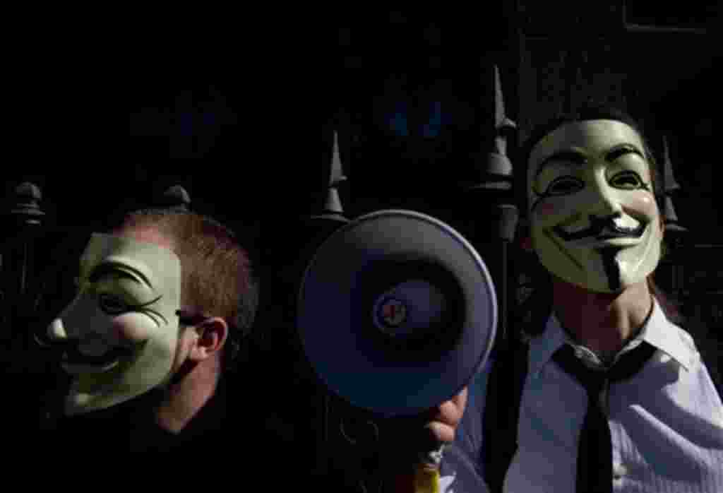 Personas con máscaras gritan consignas contra los banqueros y los políticos durante una manifestación convocada por la plataforma 'Democracia real ya' en Madrid, 15 de mayo 2011.