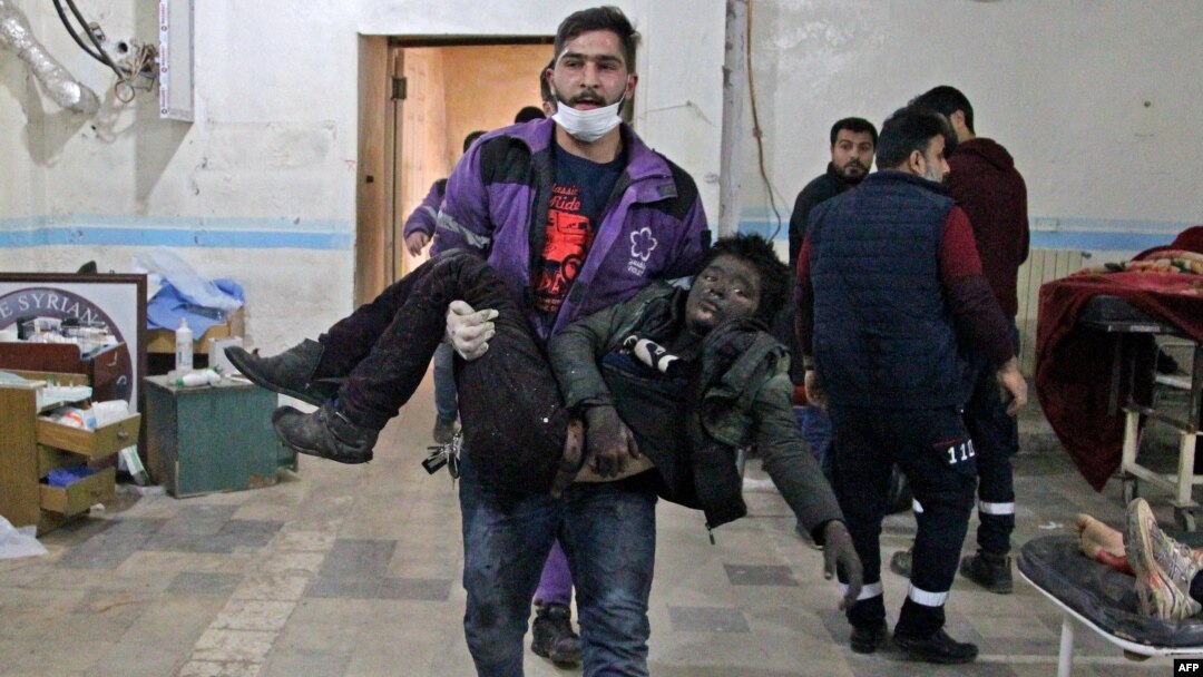 Seorang anggota Organisasi Suriah Ungu membopong anak laki-laki yang cedera ke rumah sakit darurat menyusul serangan udara oleh rezim di sebuah pasar di Idlib, Suriah, 15 Januari 2020.