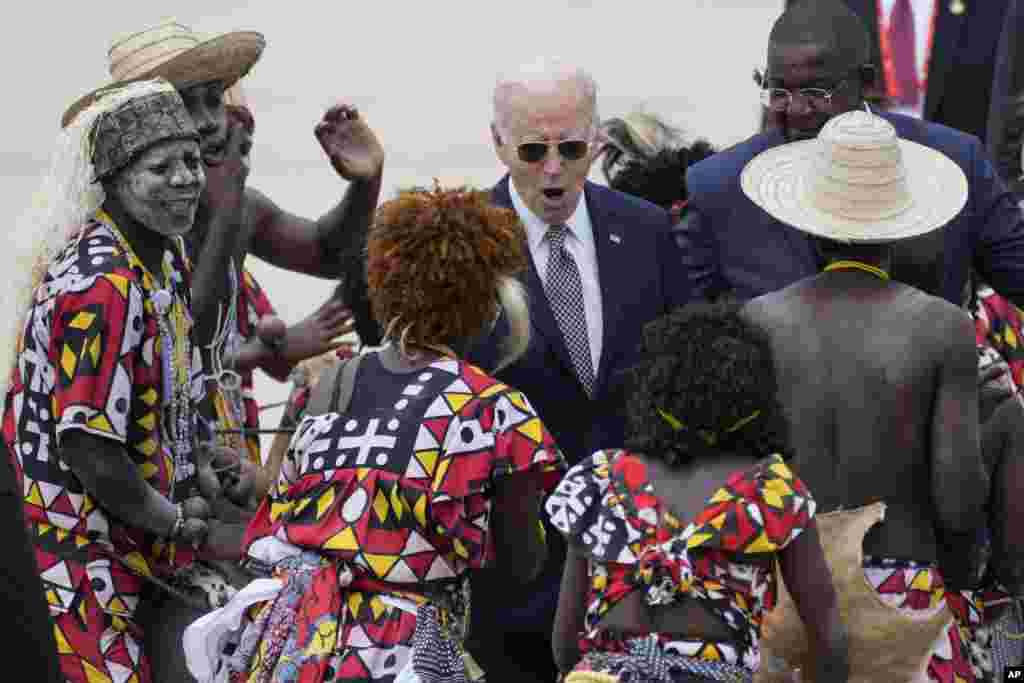 President Joe Biden watches a traditional dance after arriving at Catumbela airport in Angola.