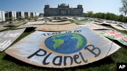 Activists place thousands of protest placards in front of the Reichstag building, home of the German federal parliament, Bundestag, April 24, 2020, staging a long-planned global climate demonstration online because of restrictions on public protests durin
