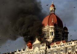 FILE - Flames gush out of The Taj Mahal Hotel in Mumbai, Nov. 27, 2008.
