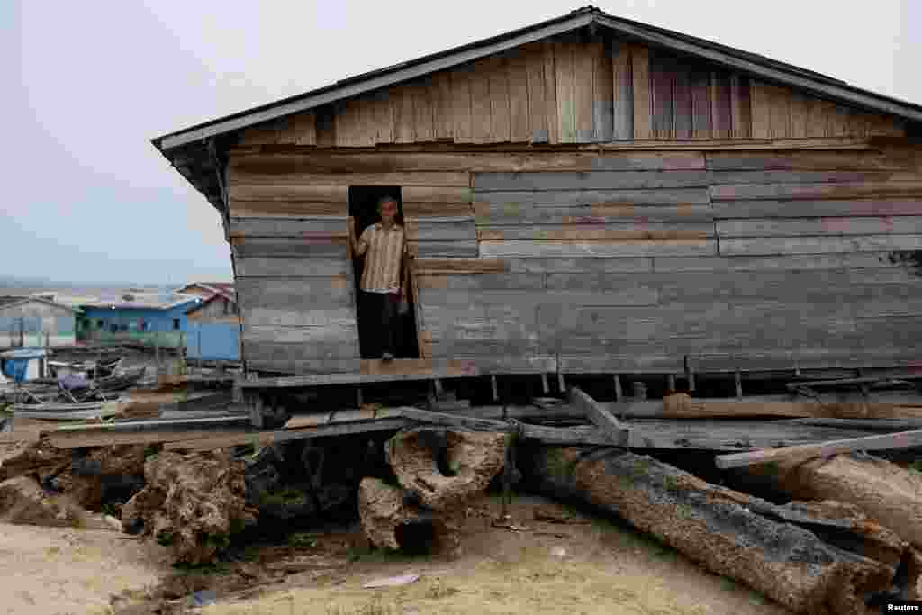 Vicente stays at the door of his floating house aground on the dry area of Lake Tefe during the worst drought on record that has lowered the water level of the rivers and lakes in the Amazon basin to historic lows, in Tefe, Amazonas state, Brazil, Sept. 18, 2024.