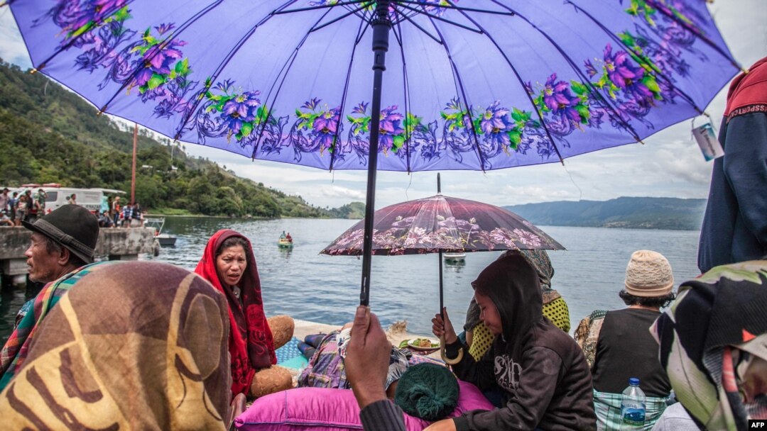 Keluarga kerabat korban kapal tenggelam KM Sinar Bangun sedang menunggu kedatangan tim SAR yang sedang mencari korban di Danau Toba, 20 Juni 2018.