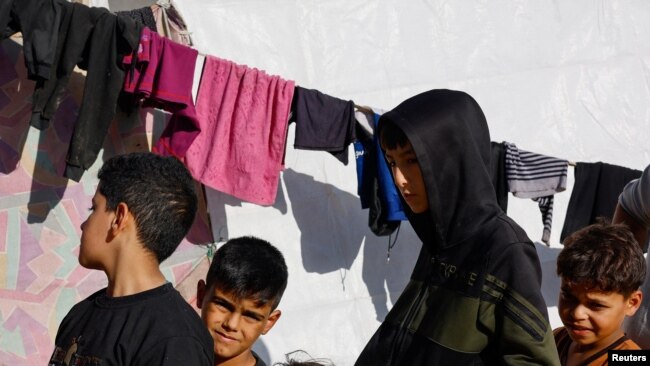 Palestinos desplazados que huyeron de sus casas debido a los ataques israelíes se refugian en un campamento cerca de la frontera con Egipto, en Rafah, el 11 de diciembre.