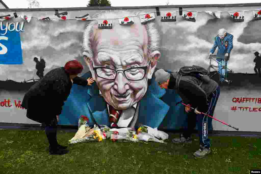 People view a mural of late record-breaking centenarian Captain Tom Moore in Two Gates, Tamworth, Britain. The 100-year-old World War II veteran who raised millions for health workers, died, Feb. 2, after testing positive for Covid-19.