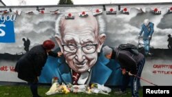 People view a mural of late record-breaking centenarian Captain Tom Moore, who died on Tuesday, in Two Gates, Tamworth, Britain, Feb. 3, 2021.