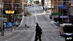 A man walks along the main road in the central business district of Sydney, June 26, 2021, as Australia's largest city entered a two-week lockdown to contain an outbreak of the highly contagious delta variant. 