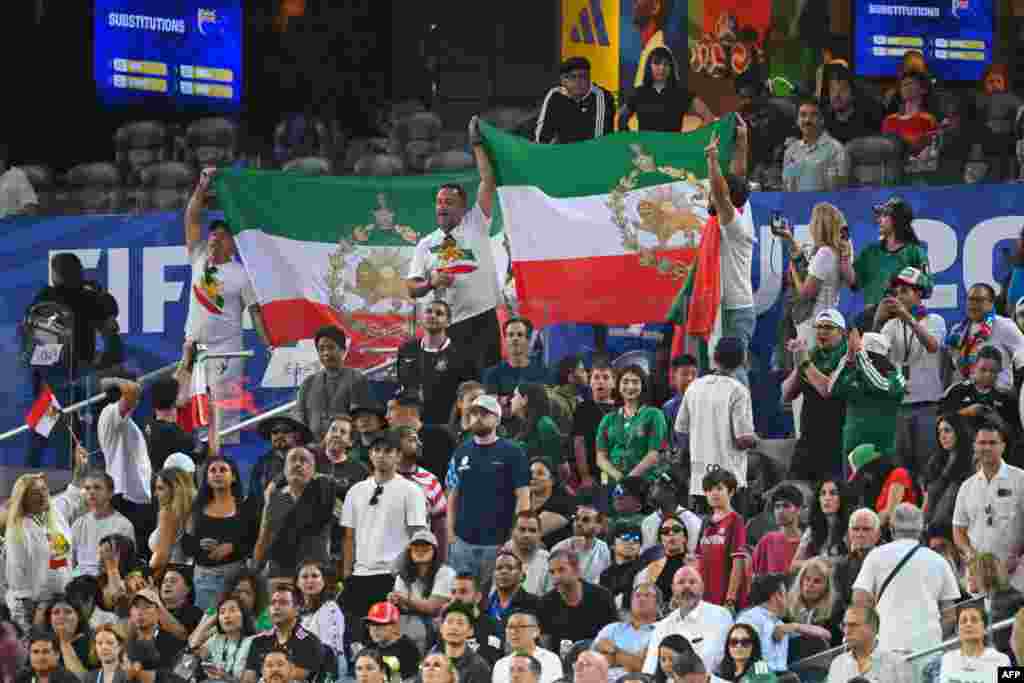 هواداران ایرانی با پرچم‌های شیر و خورشید، در جریان دیدار ایران و نیوزیلند در جام جهانی ۲۰۲۶ تیم ملی را تشویق می‌کنند.