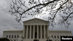 FILE - People wait in line outside the U.S. Supreme Court to hear the orders being issued, in Washington, March 18, 2019. 