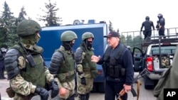 FILE - In this Aug. 23, 2020, image from video provided by state media, Belarus President Alexander Lukashenko greets riot police near the Palace of Independence in Minsk, Belarus. A wave of COVID-19 has spread through Belarusian jails.