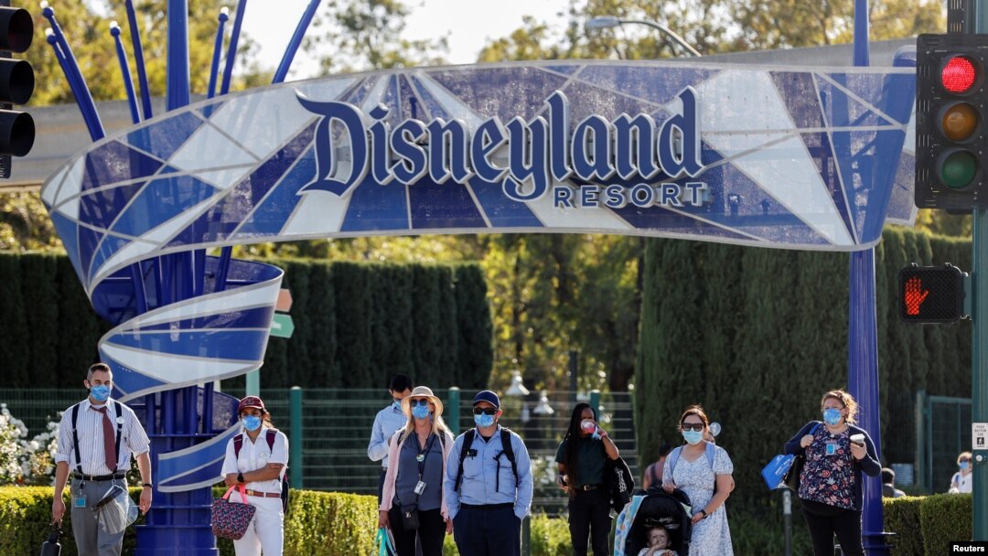 Para pengunjung menunggu di bawah papan nama Disneyland Resort di Disneyland Park pada hari dibukanya kembali Disney California Adventure di tengah pandemi COVID-19, di Anaheim, California, AS, 30 April 2021. (REUTERS/Mario Anzuoni)
