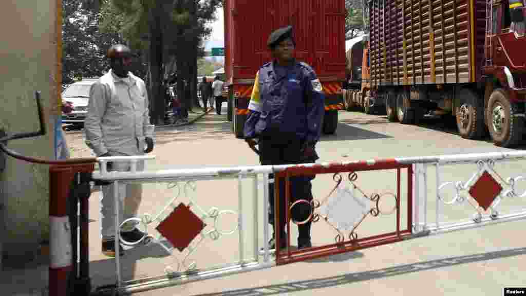 Une policère et un agent de la sécurité congolais au poste de frontière séparant la République Dénocratique du Congo et le Rwanda, le 29 aout 2013. Reuters/Thomas Mukoya 