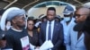 Protest organizer Setlhomo Tshwanelang, left, presents a petition to Minister of Trade Tiroeaone Ntsima, in Gaborone, Bostwana, Nov. 18, 2024.