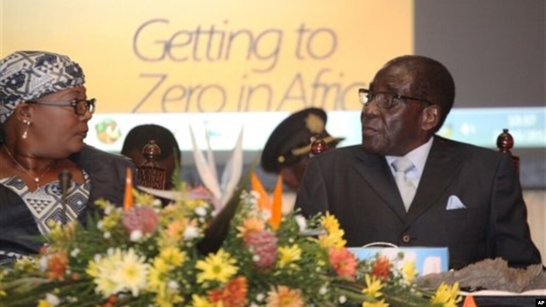 Zimbabwean Deputy Prime Minister Khupe, left, chats with President Mugabe at a women's empowerment event, Harare, May 24,2012.