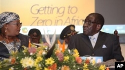 Zimbabwean Deputy Prime Minister Khupe, left, chats with President Mugabe at a women's empowerment event, Harare, May 24,2012.