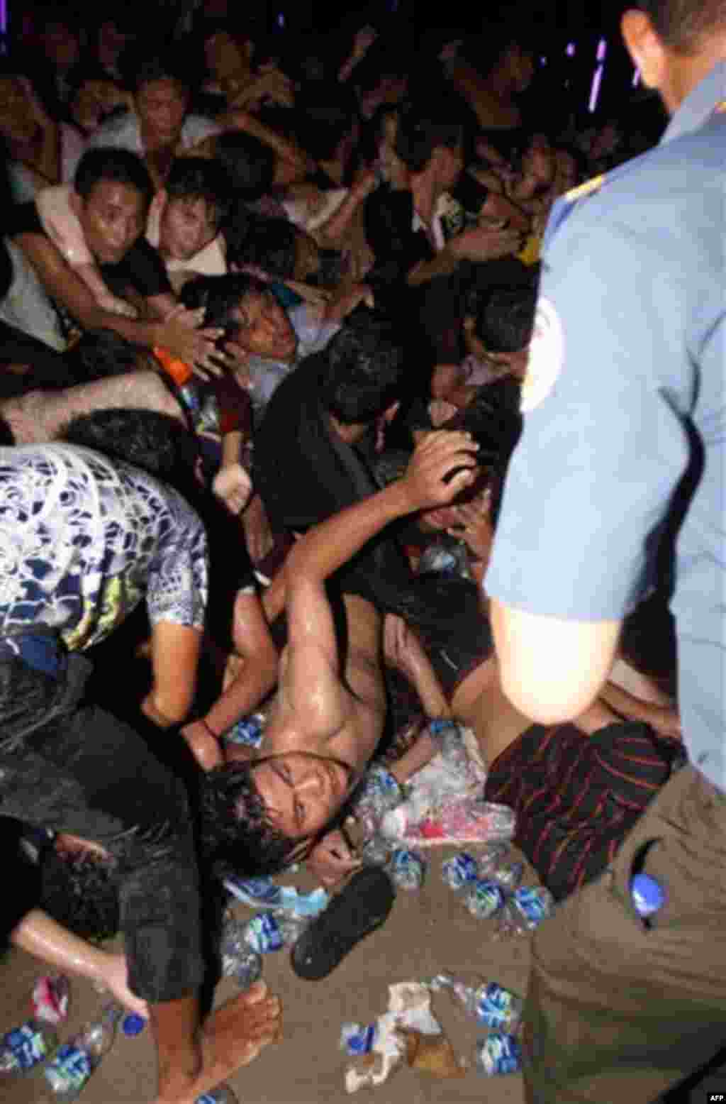 An injured Cambodian seeks help after a stampede onto a bridge during the last day of celebrations of the water festival in Phnom Penh, Cambodia, Monday, Nov. 22, 2010. Thousands of people celebrating a water festival on a small island in a Cambodian riv