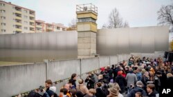 People attend a flower-laying ceremony on the 35th anniversary of the felling of the Berlin Wall at the Berlin Wall Memorial 0n Nov. 9, 2024.