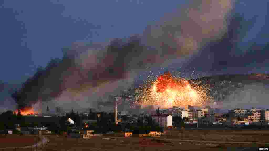 Smoke and flames rise over Syrian town of Kobani after an airstrike, as seen from the Mursitpinar crossing on the Turkish-Syrian border in the southeastern town of Suruc, Sanliurfa province, Oct. 20, 2014. 