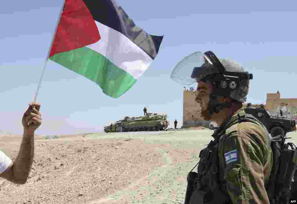 Palestinian demonstrators confront Israeli soldiers during a demonstration in an area known as Rajm al-Naqa, in Sair village east of the West Bank city of Hebron, after Israeli settlers took over a building in the area.