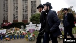 People walk past a makeshift memorial outside the Tree of Life synagogue following Saturday's shooting at the synagogue in Pittsburgh, Pennsylvania, Oct. 29, 2018. 