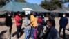 FILE - People queue to recieve COVID-19 vaccinations at a clinic in Harare, Zimbabwe, July 8, 2021.