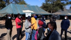 FILE - People queue to recieve COVID-19 vaccinations at a clinic in Harare, Zimbabwe, July 8, 2021.