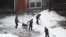 Workers clear snow from a courtyard after an overnight snowfall in Beijing on Dec. 11, 2023.