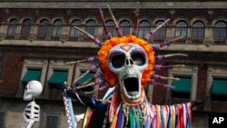 Performers in costume attend a Day of the Dead parade in Mexico City, Sunday, Oct. 27, 2019.