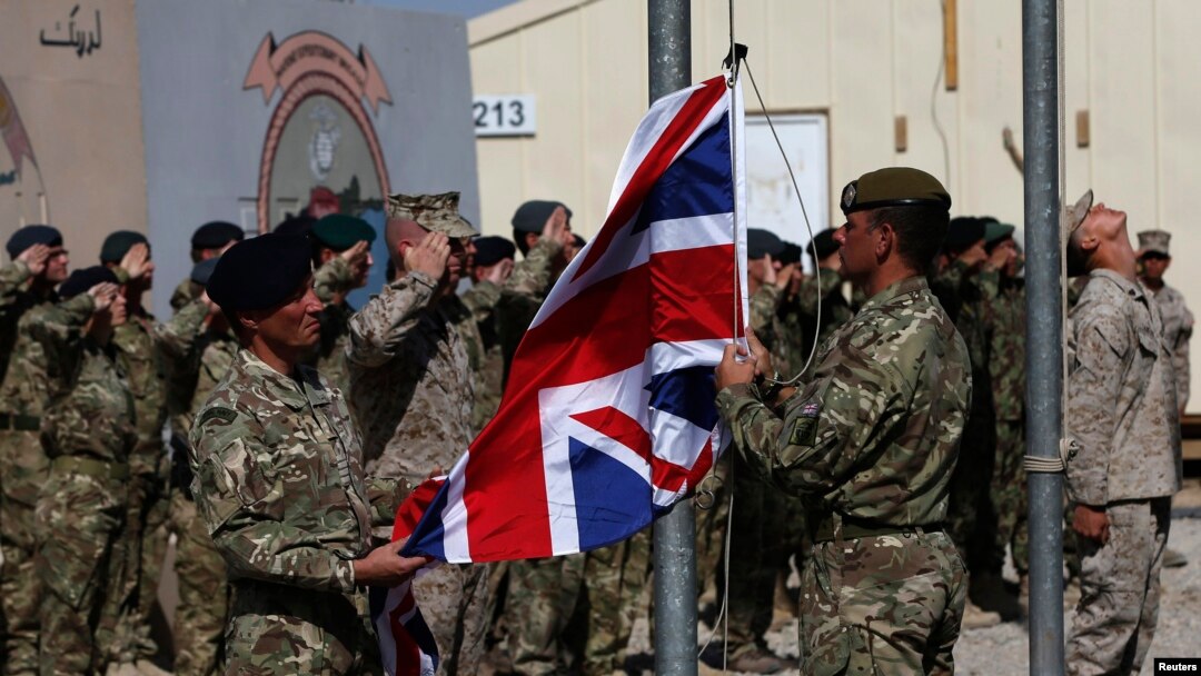 FILE - British troops lower the Union flag during a ceremony marking the end of operations for U.S. Marines and British combat troops in Helmand, Afghanistan, Oct. 26, 2014. 