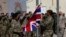 FILE - British troops lower the Union flag during a ceremony marking the end of operations for U.S. Marines and British combat troops in Helmand, Afghanistan, Oct. 26, 2014. 