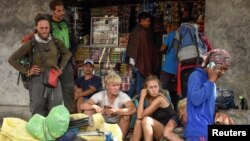 Para pendaki Indonesia dan asing terlihat di Desa Sembalun, Lombok Timur, setelah berhasil turun dari Gunung Merapi, 29 Juli 2018. (Foto: Antara via Reuters)