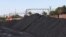 FILE: A Transnet Freight Rail train is seen next to tons of coal mined from the nearby Khanye Colliery mine, at the Bronkhorstspruit station, in Bronkhorstspruit, around 90 kilometres north-east of Johannesburg, South Africa. Taken 4.26.2022