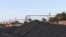 FILE: A Transnet Freight Rail train is seen next to tons of coal at the Bronkhorstspruit station, in Bronkhorstspruit, around 90 kilometers north-east of Johannesburg, South Africa, 4.26.2022