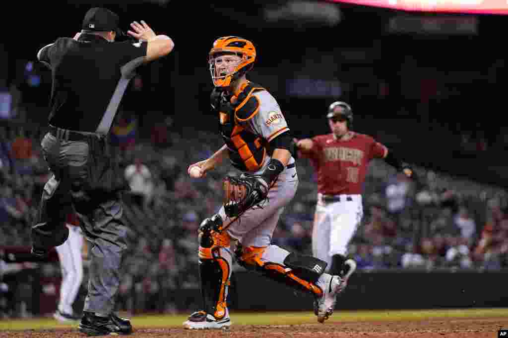  Umpire Nick Mahrley (L) calls a foul ball as San Francisco Giants catcher Buster Posey, middle, questions the call while Arizona Diamondbacks&#39; Tim Locastro (R) runs toward home plate during the ninth inning of a baseball game in Phoenix, AZ, May 26, 2021