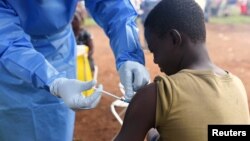 FILE - A Congolese health worker administers Ebola vaccine to a boy who had contact with an Ebola sufferer in the village of Mangina, in North Kivu province of the Democratic Republic of Congo, Aug. 18, 2018.