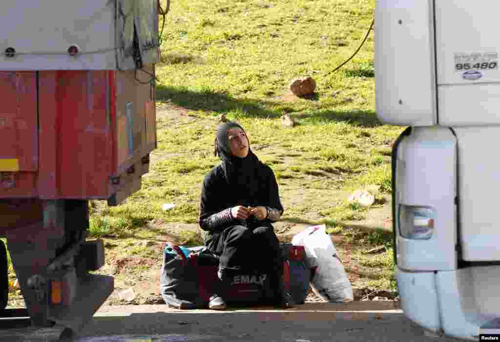 A Syrian woman waits for the opening of Cilvegozu border gate near the town of Reyhanli in Hatay province at the Turkish-Syrian border. 