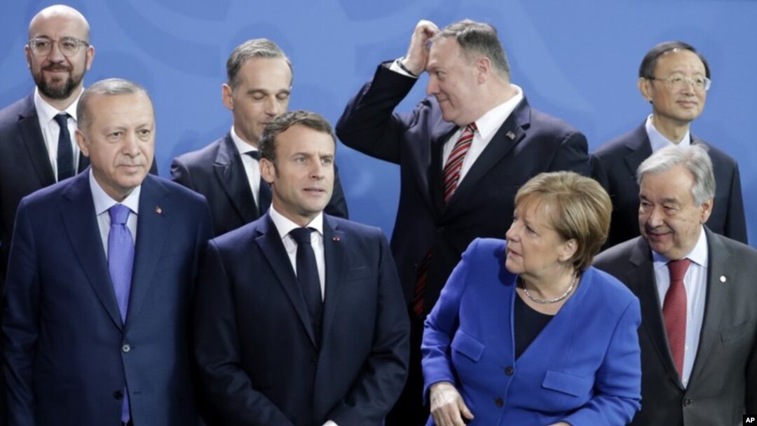 La canciller de Alemania, Angela Merkel, a la izquierda, espera a que lleguen los líderes que faltan para una foto de grupo en la conferencia sobre Libia en la Cancillería en Berlín, Alemania, el domingo 19 de enero de 2020. Foto AP. 